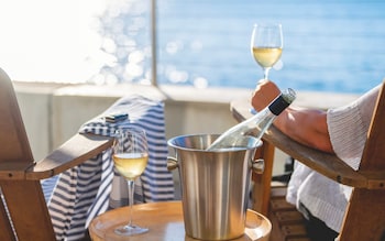 A bottle of wine is split between two people on a cruise