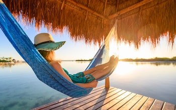 Woman relaxing on a hammock under a palapa, Mexico