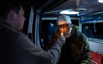 Serhii smokes a cigarette before he is evacuated to a hospital